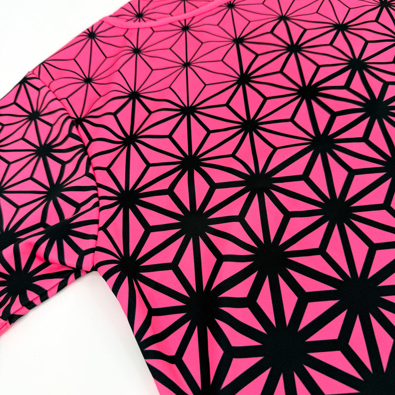 Asanoha pink UV baseball jersey by First Earth – oversized rave jersey glowing under blacklight, adorned with sacred Asanoha geometric design