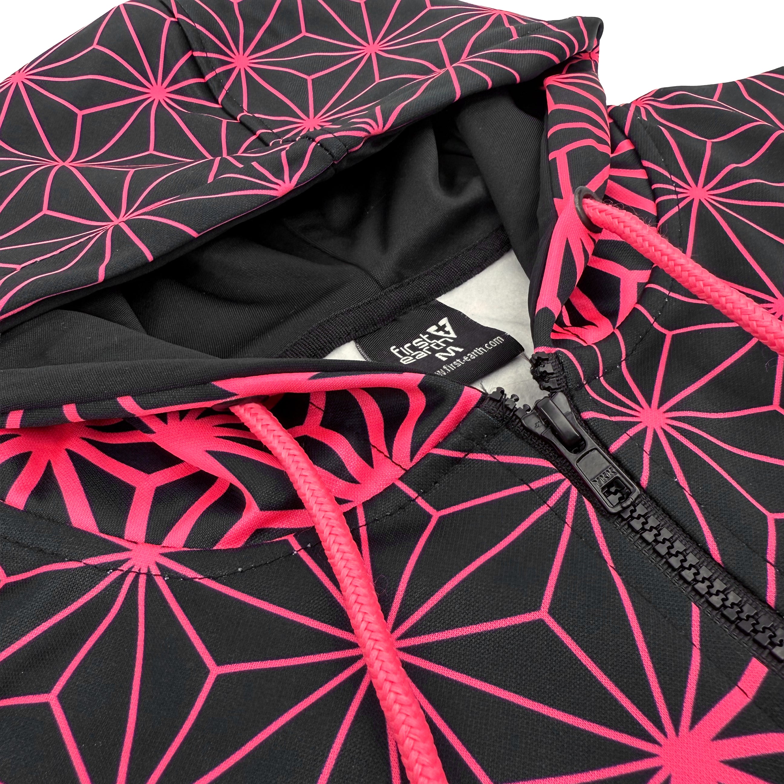 Asanoha pink UV zip‑up hoodie by First Earth – cozy rave hoodie featuring glowing sacred geometry, thumb holes, and relaxed scoop hem for festival layering 