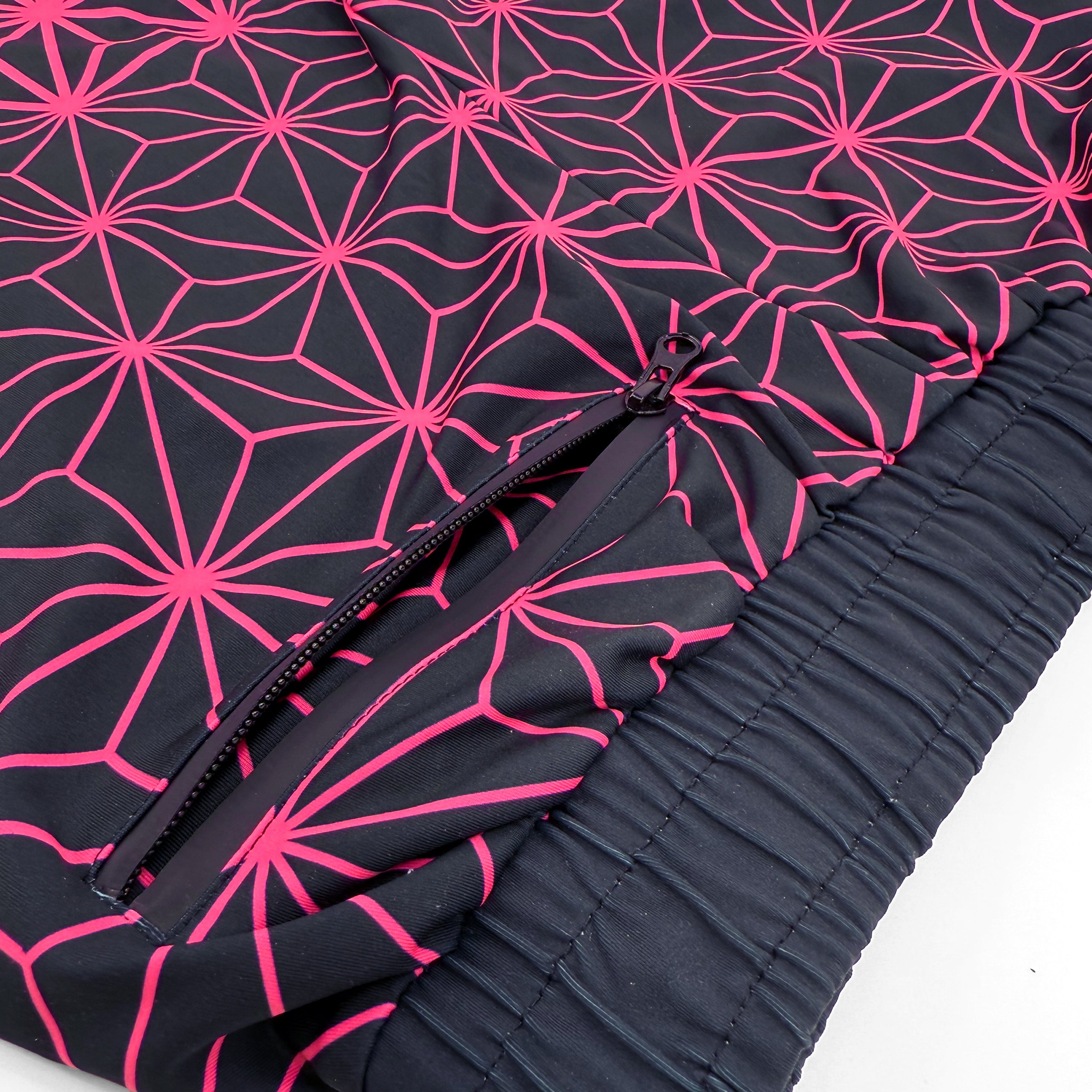 Asanoha pink UV joggers by First Earth – festival-friendly pants with glowing sacred geometry design, breathable fabric, zip pockets, and relaxed fit waistband 