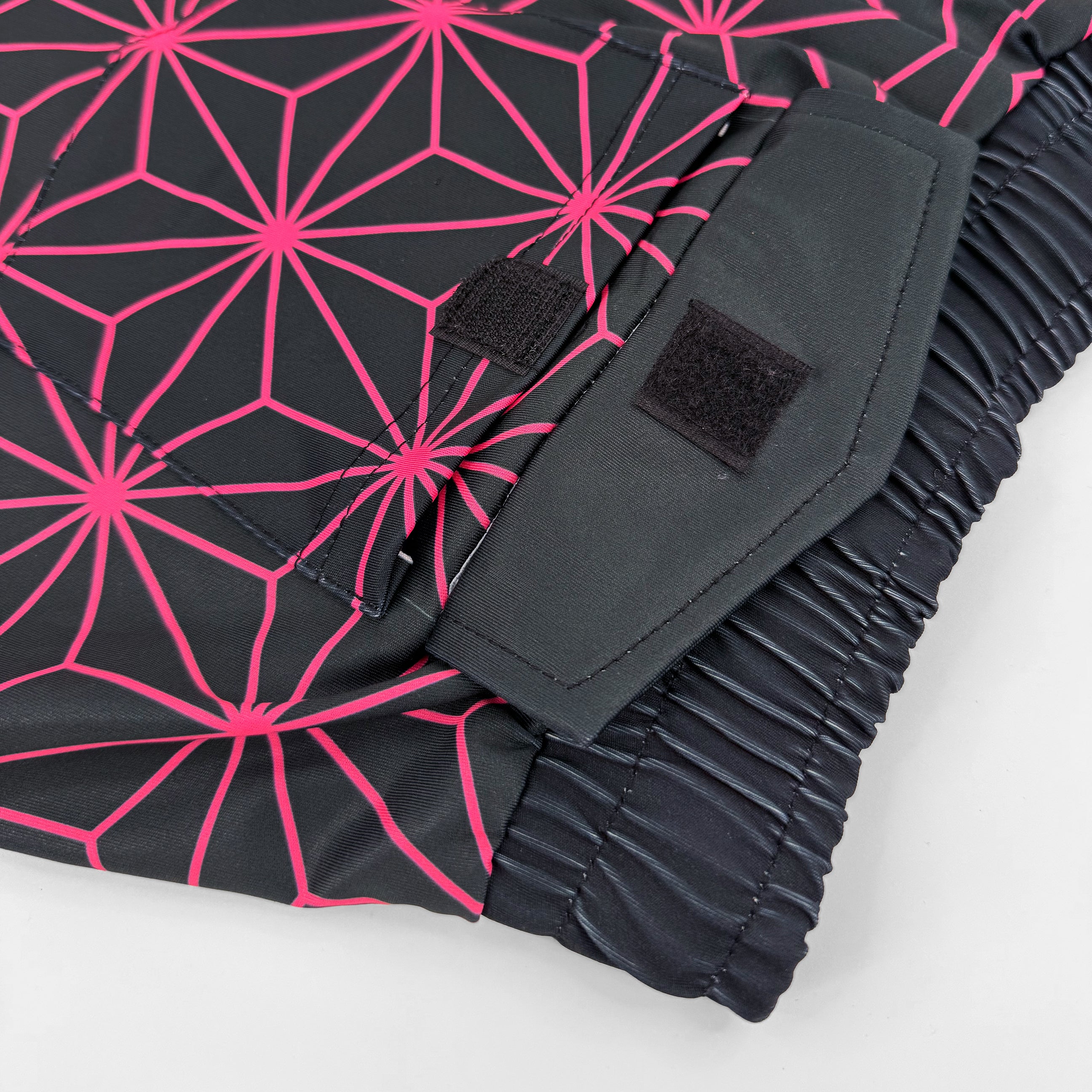 Asanoha pink UV shorts by First Earth – rave-ready shorts with glowing sacred geometry design under blacklight, soft breathable fabric, zip and velcro pockets for hands-free flow