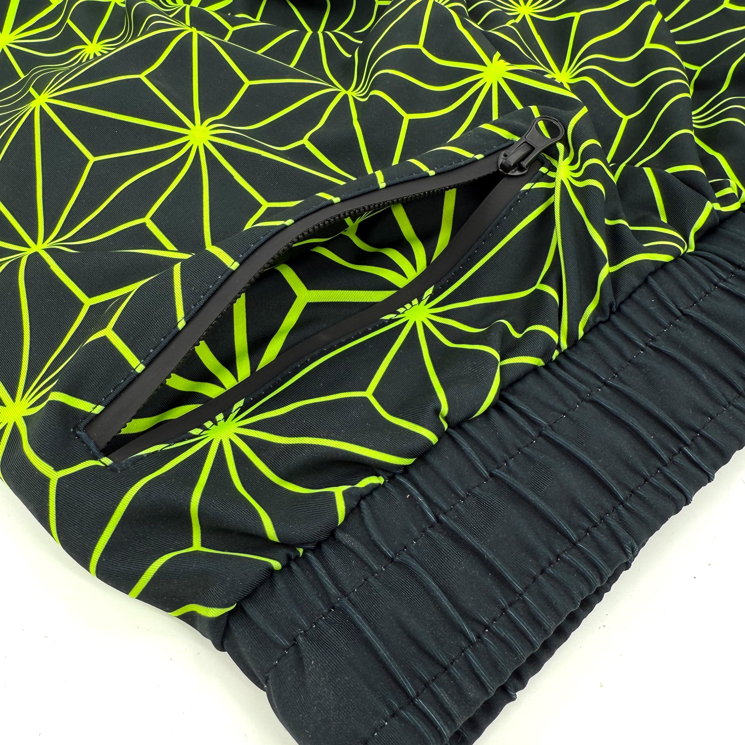 Asanoha yellow UV joggers by First Earth – rave-ready pants with glowing Asanoha sacred geometry, soft breathable polyester, zip pockets, and comfortable elastic waistband 