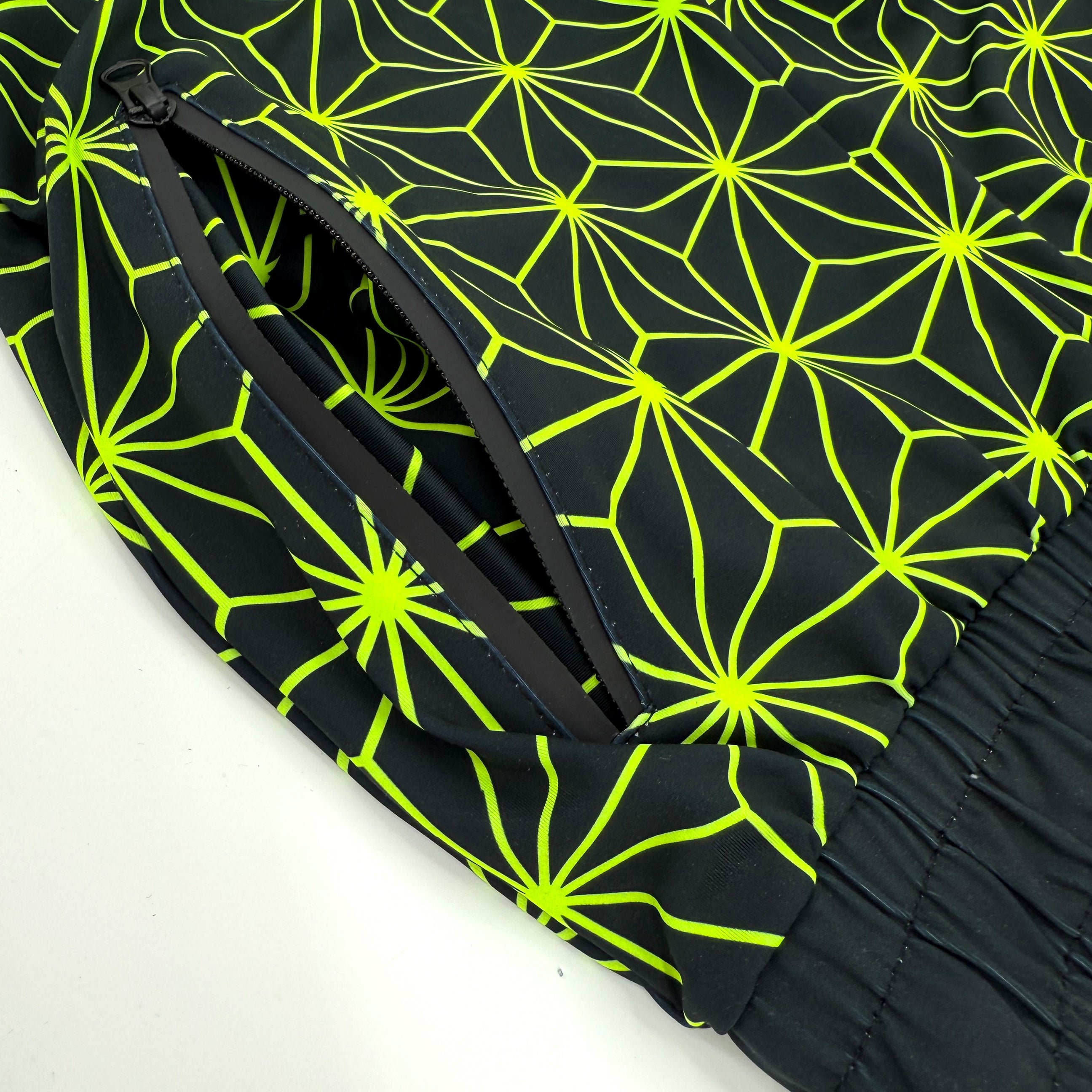 Asanoha yellow UV joggers by First Earth – rave-ready pants with glowing Asanoha sacred geometry, soft breathable polyester, zip pockets, and comfortable elastic waistband 