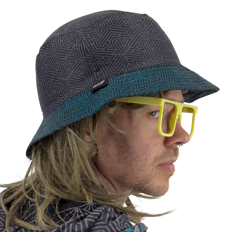 First Earth Shadow reversible bucket hat side profile showing grey maze pattern crown and teal patterned brim