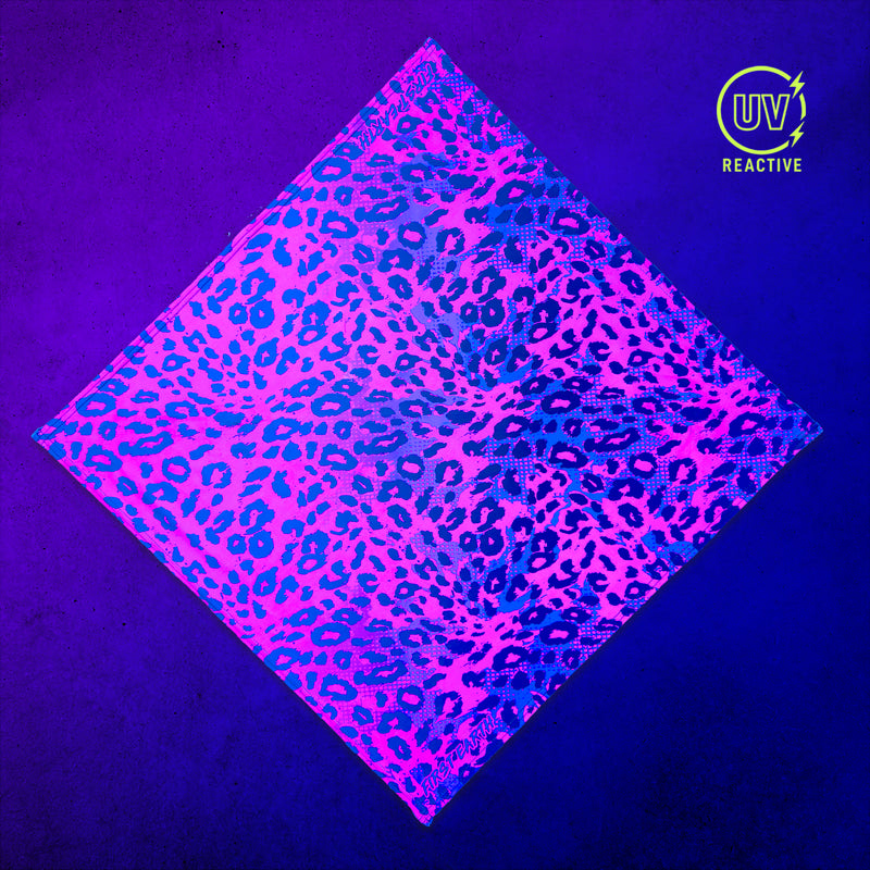 First Earth Neon Cheetah UV Glow bandana glowing under UV blacklight with pink and blue cheetah print