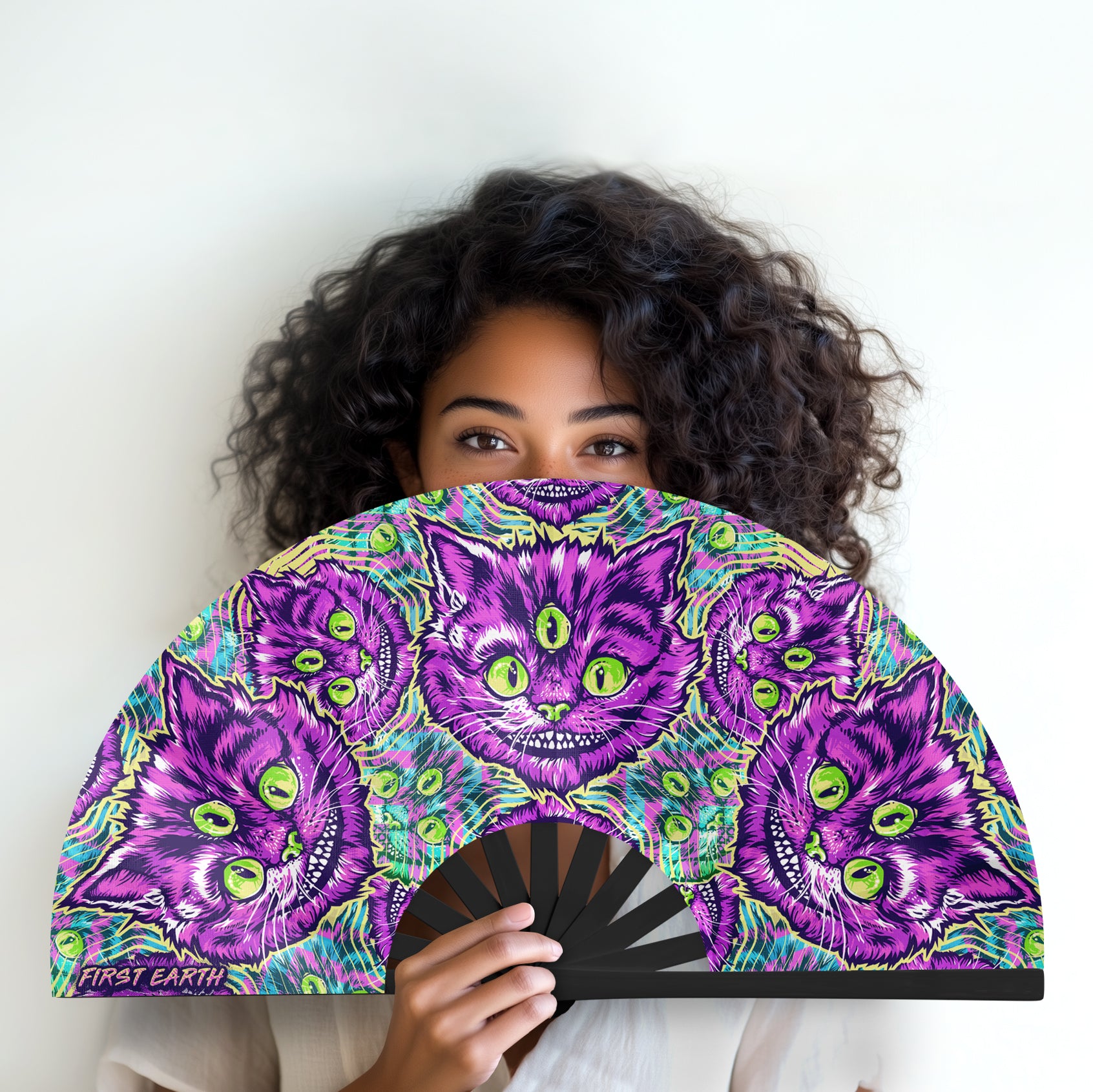 Cheshire Cat UV glow hand fan by First Earth – collapsible rave fan with glowing Cheshire Cat design, bamboo ribs, and vibrant polyester fabric for festival breeze