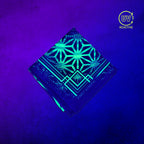 Flower of Life Green UV-reactive bandana by First Earth glowing under black light, showing the complete printed design