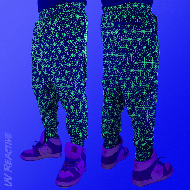 First Earth Asanoha Yellow velvet harem joggers under UV blacklight on model showing glowing yellow geometric asanoha pattern