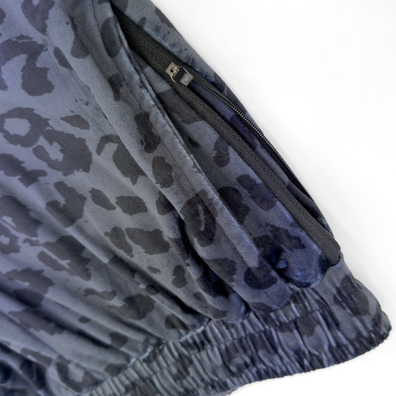 Close up of First Earth Midnight Cheetah velvet harem joggers hip zipper pocket