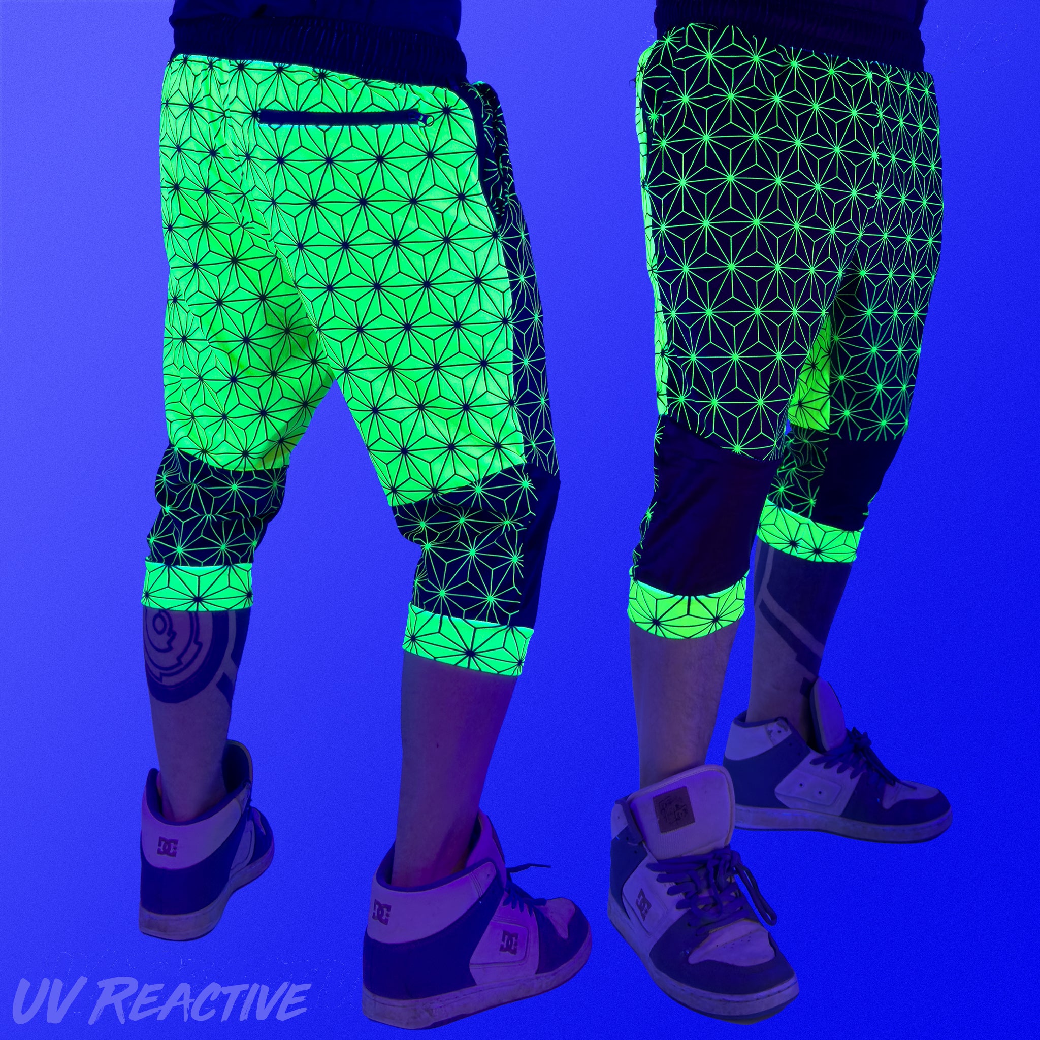 First Earth Asanoha Yellow 3/4 velvet harem shorts under UV blacklight on model, showing front and back glowing yellow pattern