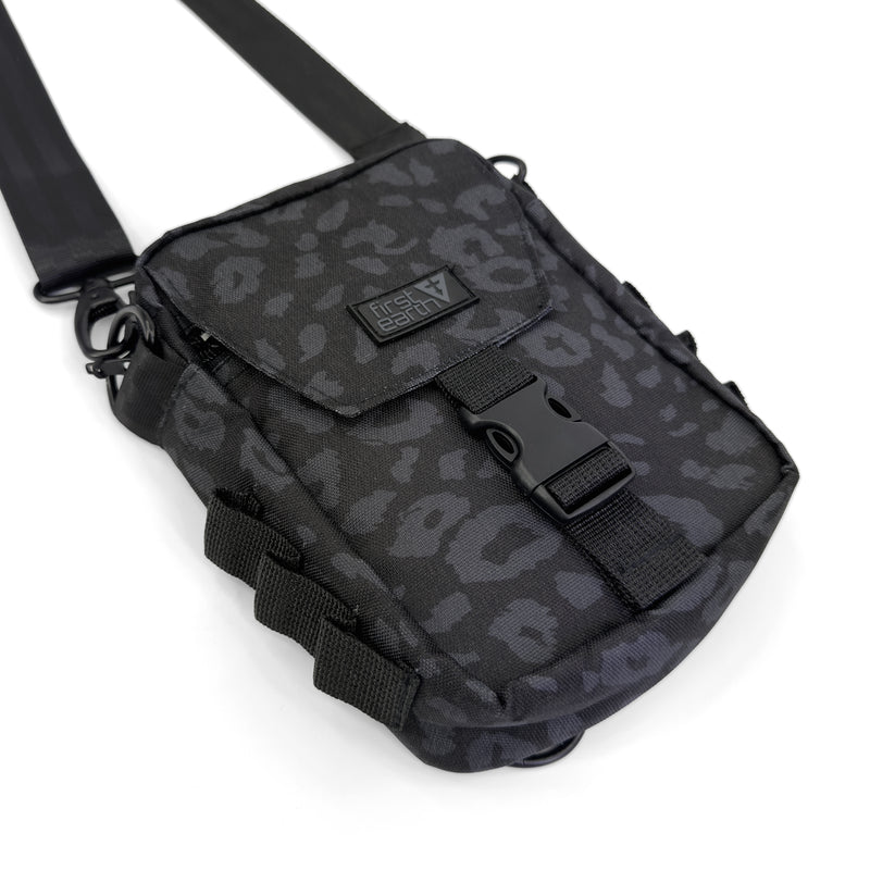 First Earth Midnight Cheetah sling bag front view with buckle closure and logo patch
