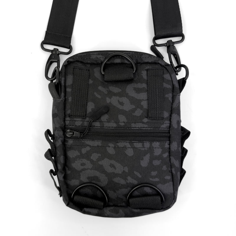 First Earth Midnight Cheetah sling bag back view with black straps and zipper pocket