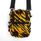 First Earth Sacred Stripes sling bag back view with orange tiger stripes, black straps, D-rings, and zipper pocket