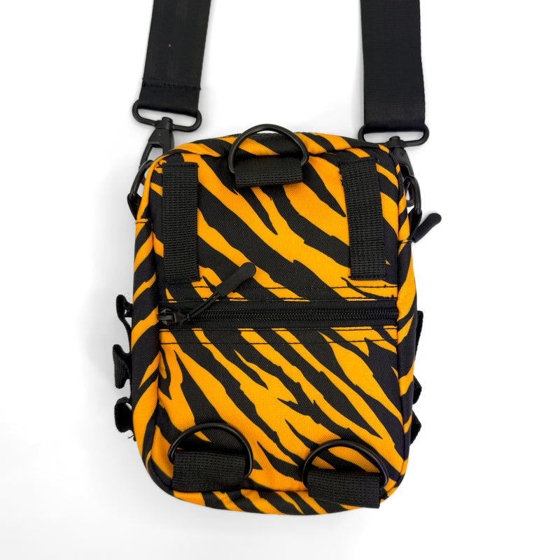 First Earth Sacred Stripes sling bag back view with orange tiger stripes, black straps, D-rings, and zipper pocket