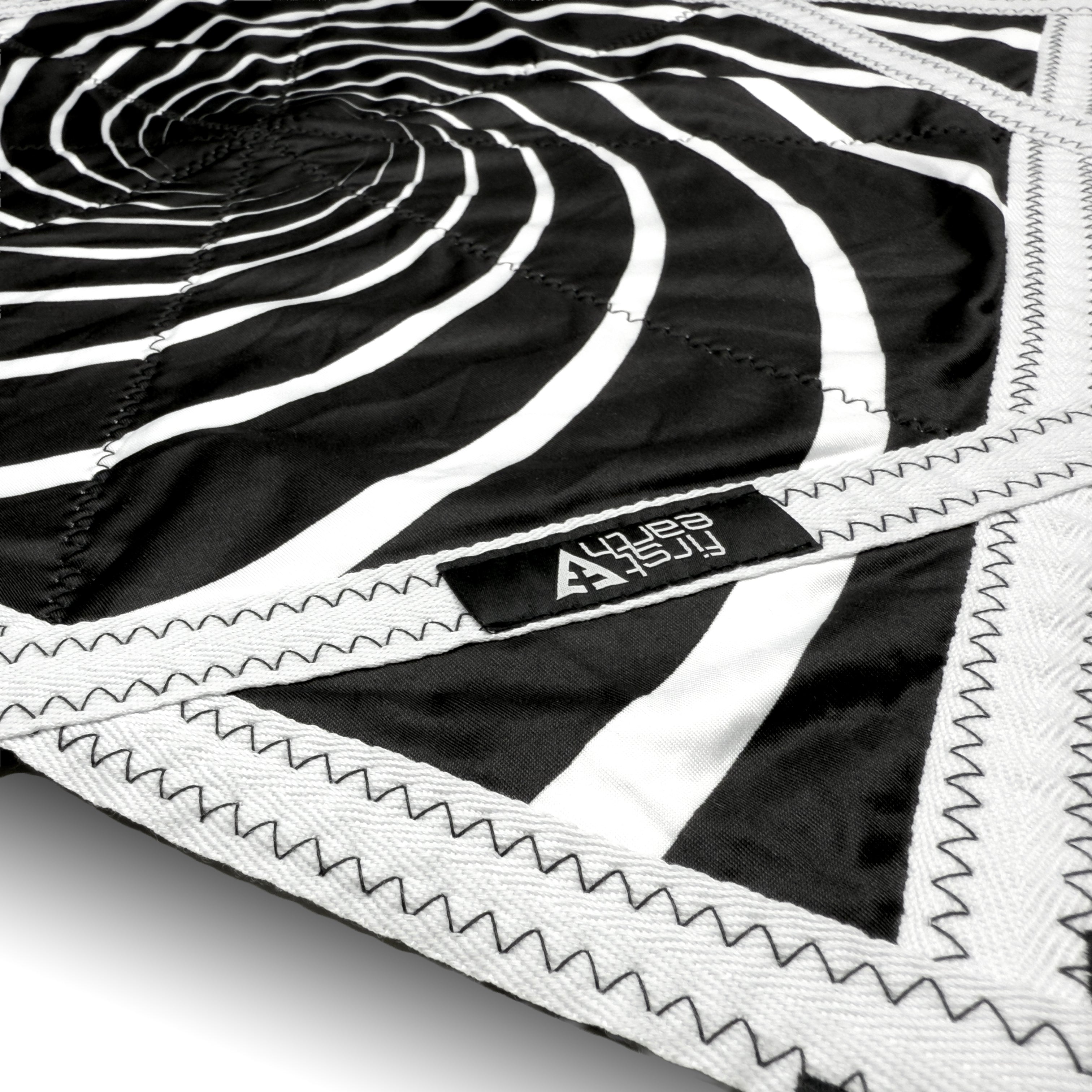 First Earth Spiral 2 UV Flow Star — black and white UV swirl rave prop made for smooth, balanced spinning.