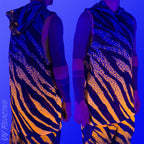First Earth Sacred Stripes UV hooded mesh tank top under blacklight on model showing glowing orange tiger stripe design front and back