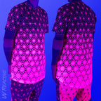 First Earth Asanoha Pink UV mesh t-shirt under blacklight on model showing glowing pink asanoha pattern front and back