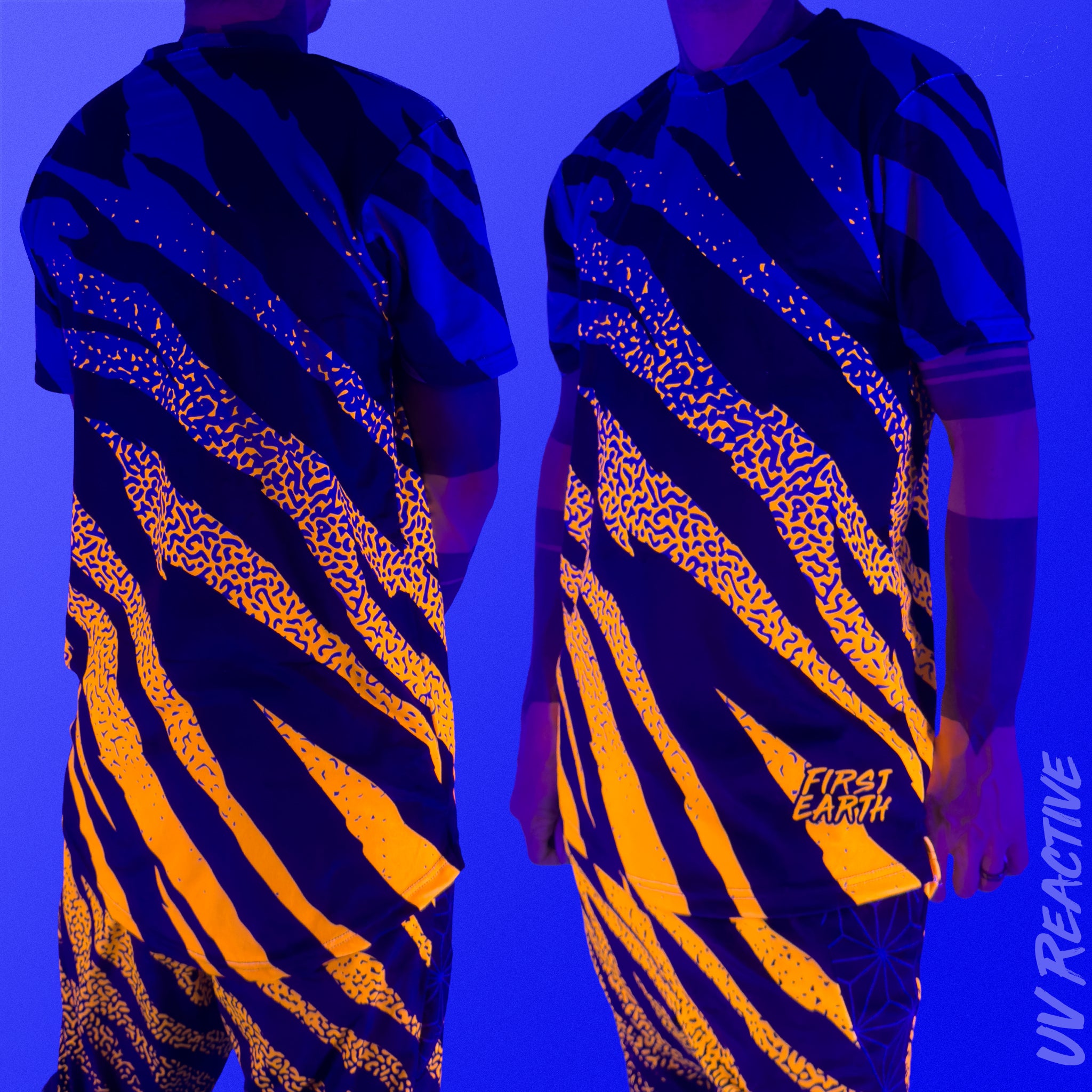 First Earth Sacred Stripes UV mesh t-shirt under blacklight on model showing glowing orange tiger stripe design front and back