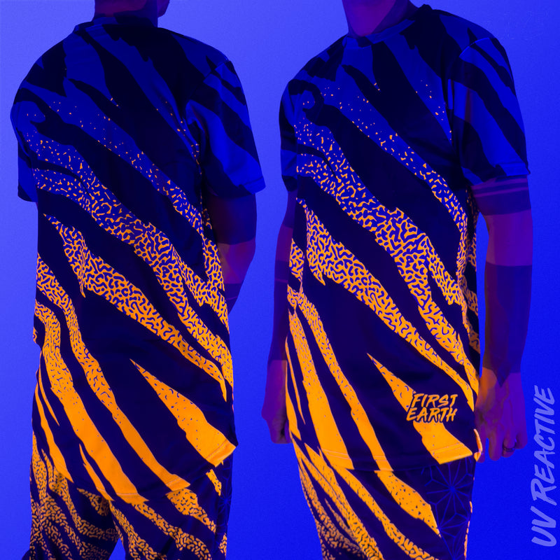 First Earth Sacred Stripes UV mesh t-shirt under blacklight on model showing glowing orange tiger stripe design front and back