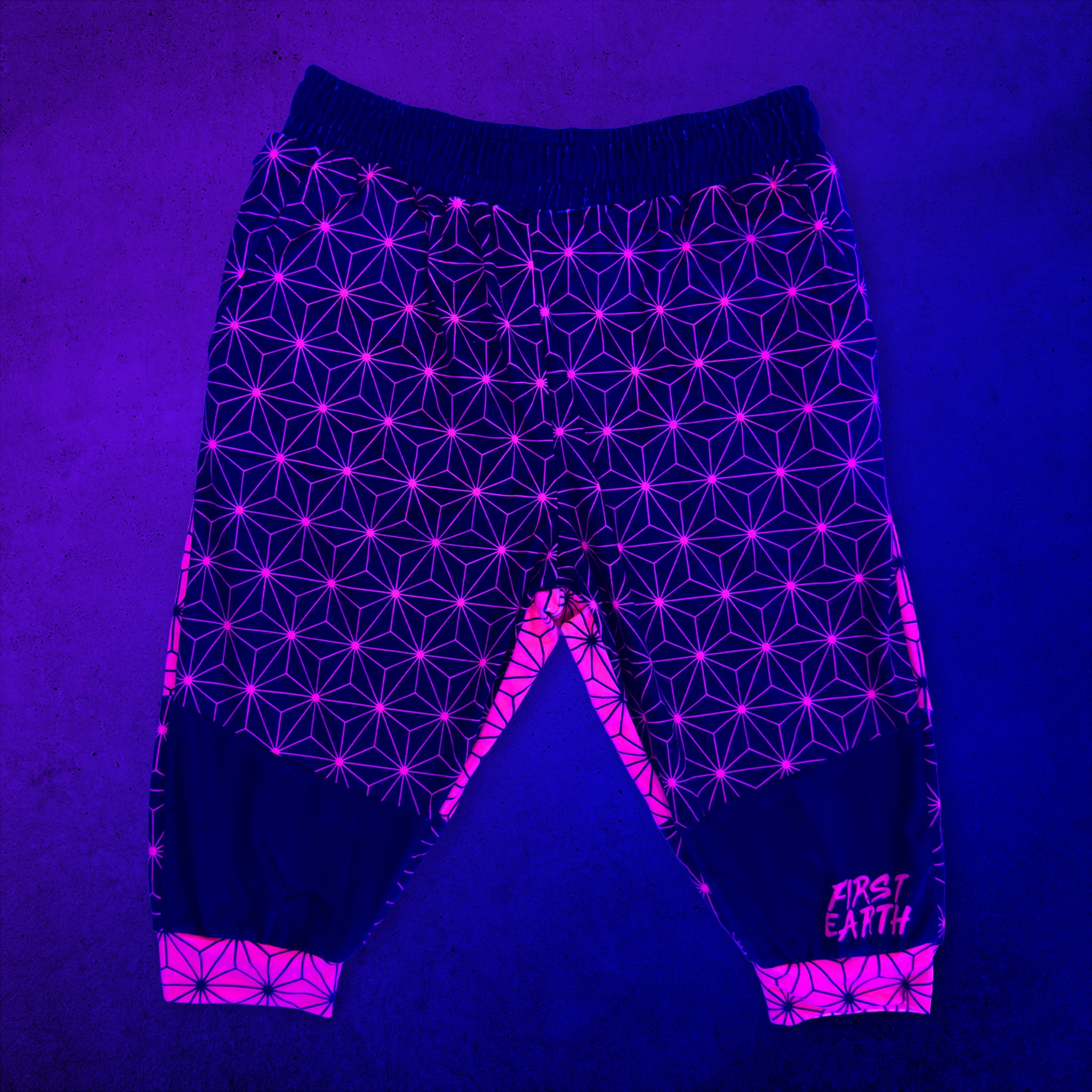 First Earth Asanoha Pink UV velvet 3/4 jogger shorts front glowing under black light