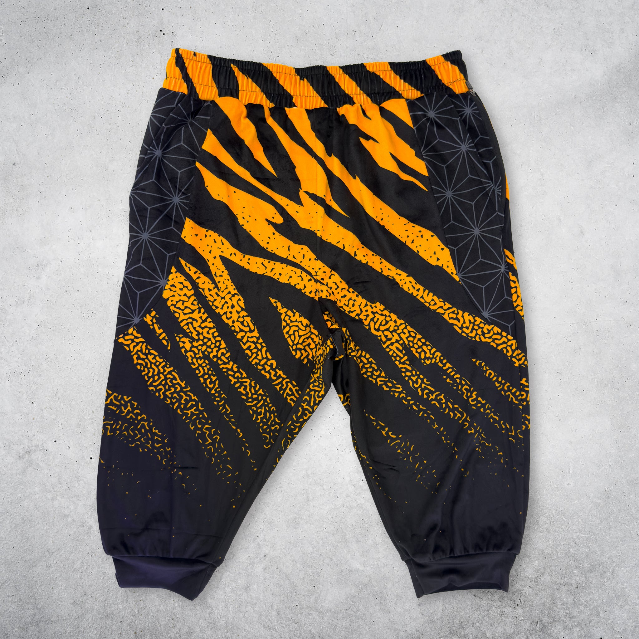 First Earth Sacred Stripes UV velvet 3/4 jogger shorts front with orange and black stripe print and geometric side panels