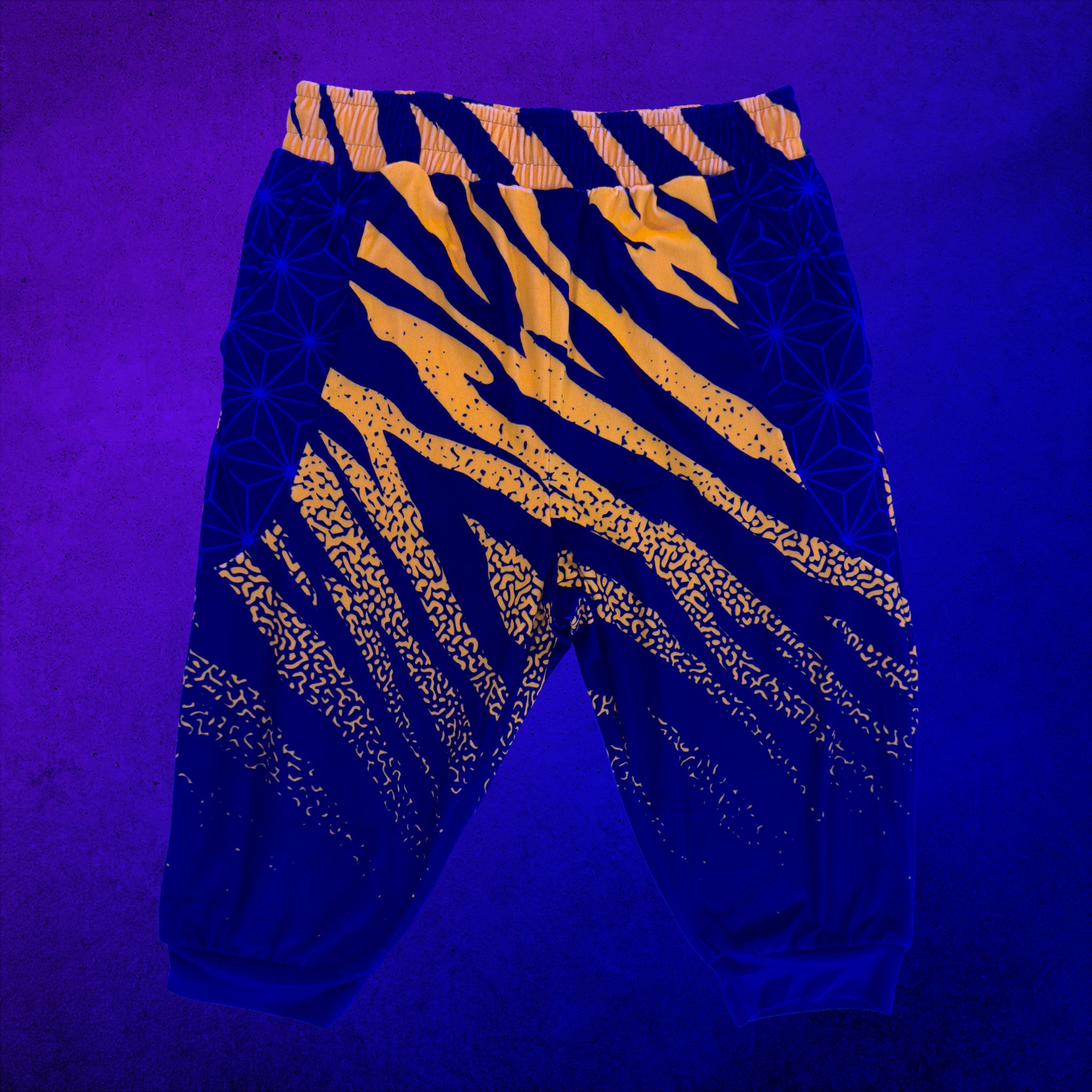 First Earth Sacred Stripes UV velvet 3/4 jogger shorts glowing under UV black light