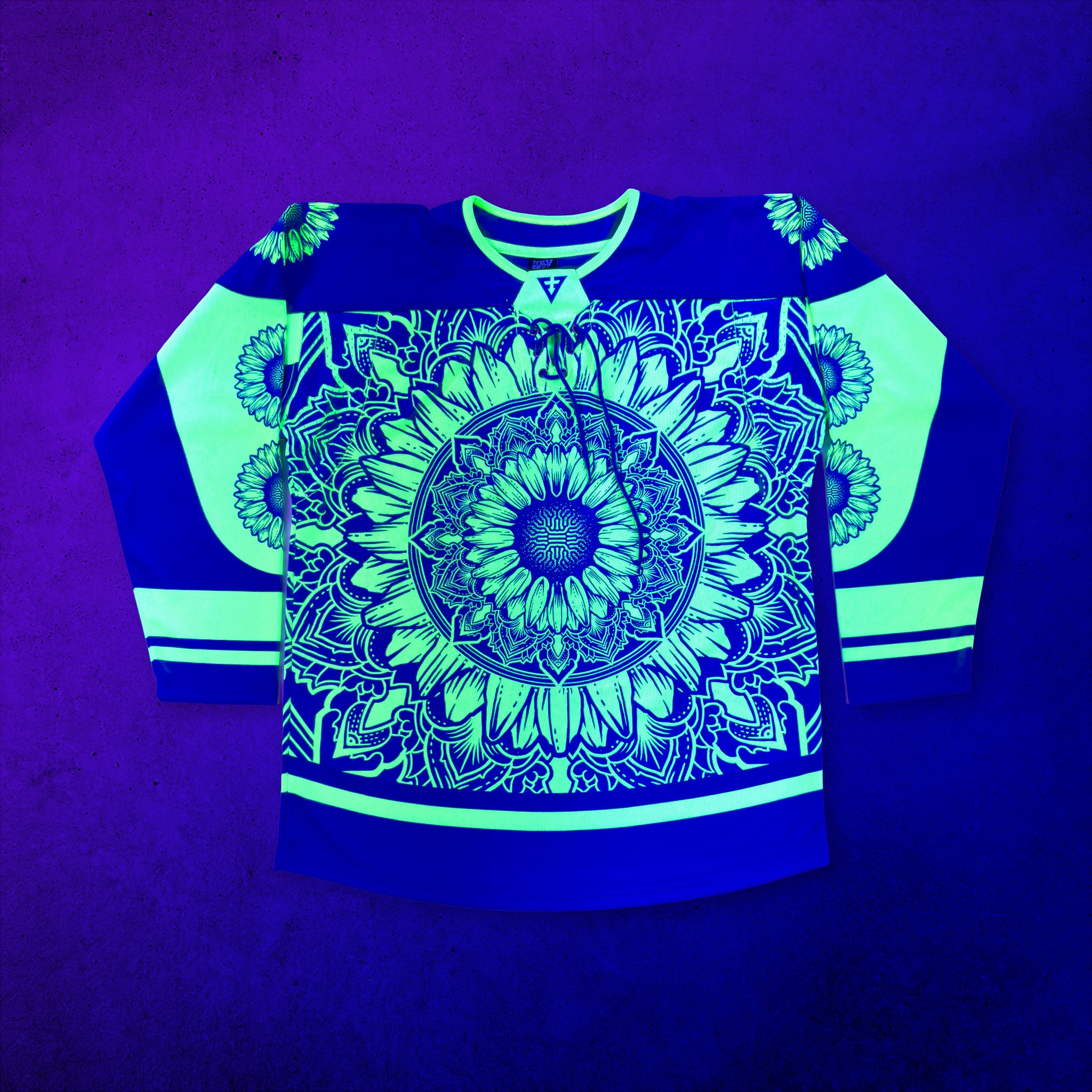 First Earth Sunflower of Life UV-reactive hockey jersey glowing bright yellow and blue under blacklight, featuring a large sunflower mandala on the front, sunflower-accented sleeves, striped details, and a front lace-up neckline